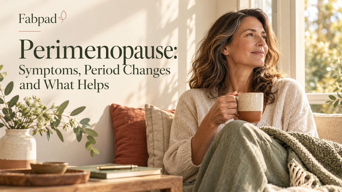 Woman in her forties relaxing by a sunny window with a cup of tea, for a guide to perimenopause symptoms and period changes
