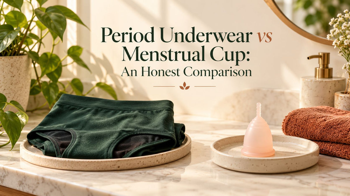 Folded green period underwear on a tray beside a pink menstrual cup on a bathroom counter